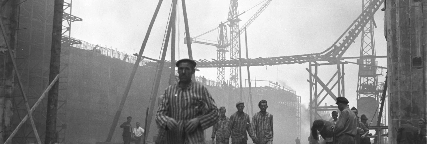 Poster von dem Tag des Gedenkens an die Opfer des Nationalsozialismus. Ein Foto geschossen von Johann Seubert im Auftrag der Nationalsozialisten. Es zeigt gehende Zwangsarbeiter auf der Bunkerbaustelle Valentin in Bremen Farge  