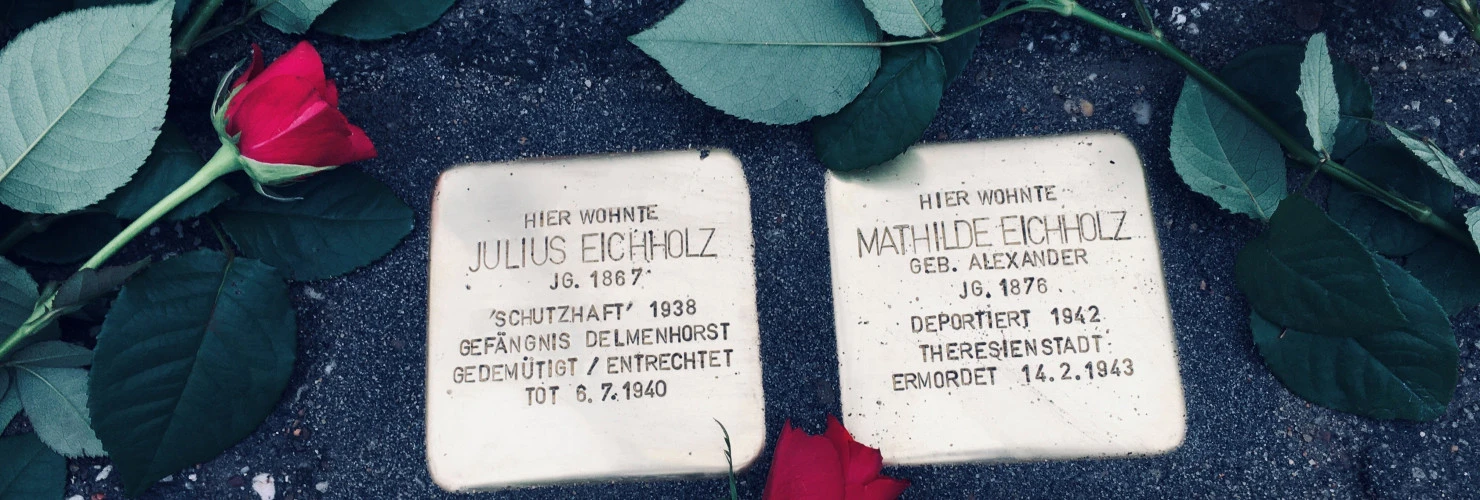 Stolpersteine von Julius Eichholz und Mathilde Eichholz. Rosen liegen um sie herum.  