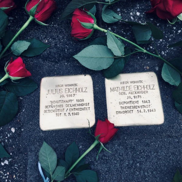 Stolpersteine von Julius Eichholz und Mathilde Eichholz. Rosen liegen um sie herum.  