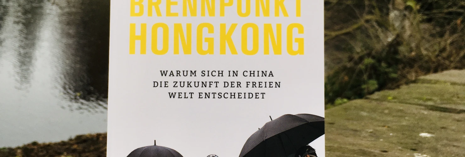 Ein Bild des Buches: "Brennpunkt Hongkong: Warum sich in China die Zukunft der freien Welt entscheidet" von Alexander Görlach mit dem Hintergrund der Mühle am Wall.  