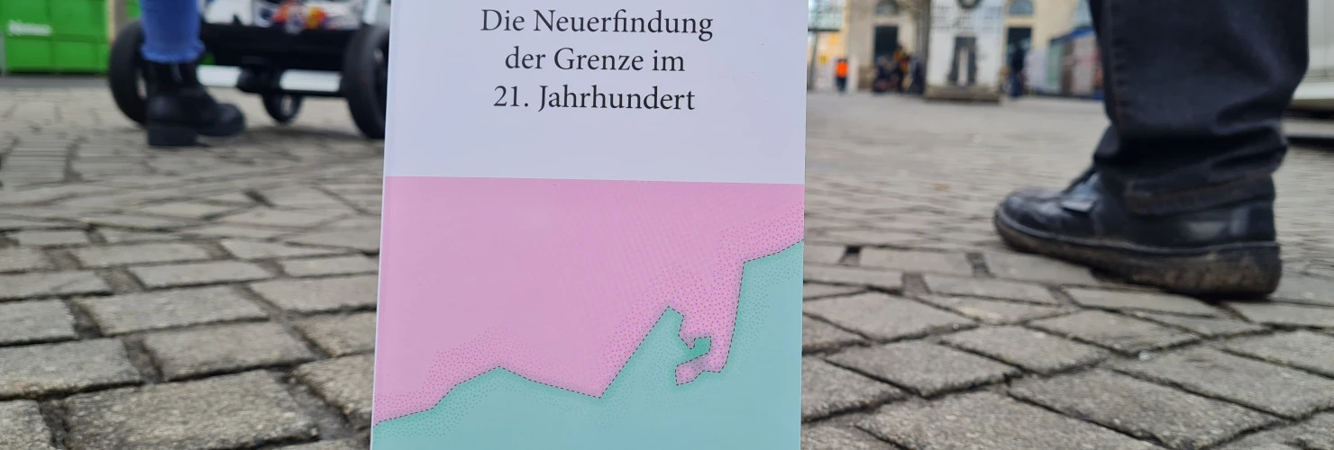 Ein Bild des Buches "Sortiermaschinen-Die Neuerfindung der Grenze im 21. Jahrhundert" von Steffen Mau mit einem Hintergrund einer städtischen Straße.  