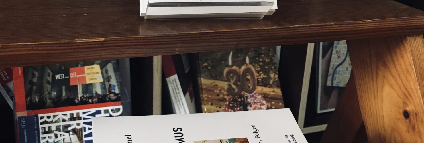Das Cover des Buches "Kolonialismus. GESCHICHTE, FORMEN, FOLGEN". In der Mitte des Buchdeckels ist die Abbildung einer Frau zu sehen, die von ihren Sklaven in einer Sänfte getragen wird.